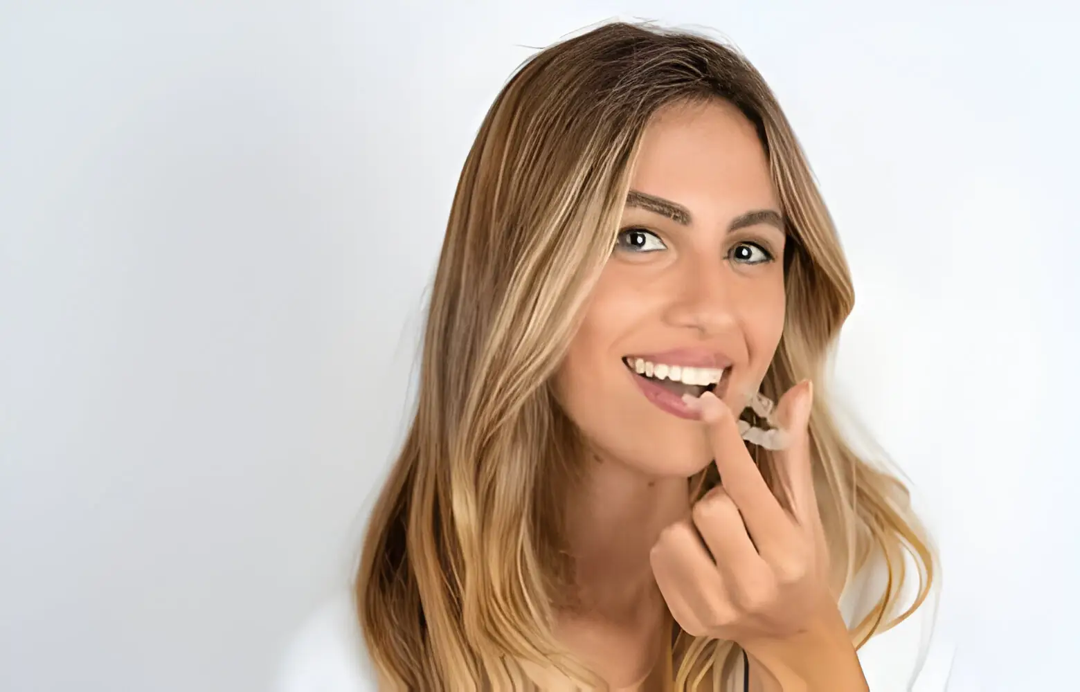 Lady carrying invisalign aligner in hand.